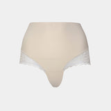 Still product image of Tummy Shaper Lace in latte, mid-waist shaping brief with lace detailing. Double-layer waistband, smooth fabric front, and lace edges designed for shaping and invisible wear under clothing.