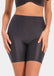 Front view of a model wearing Everyday Shaper Bermuda in black, mid-waisted seamless shapewear shorts. Cropped image showing waistband and upper thigh area, with smooth fabric and invisible finish under clothing.