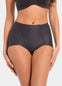 Front view of a model wearing Everyday Shaper Shorty in black, mid-waisted seamless shapewear shorts. Cropped image showing waistband and upper thigh area, with smooth fabric and seamless finish for invisible shaping under clothing.