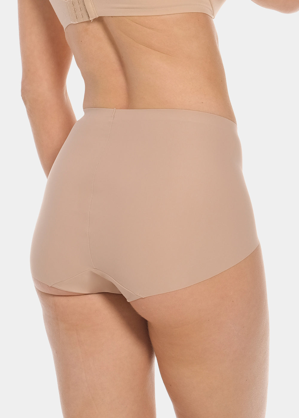 Back view of a model wearing Everyday Shaper Shorty in cappuccino, mid-waisted seamless shapewear shorts. Smooth fabric with short legs and seamless edges, providing invisible coverage across the back and upper thighs.