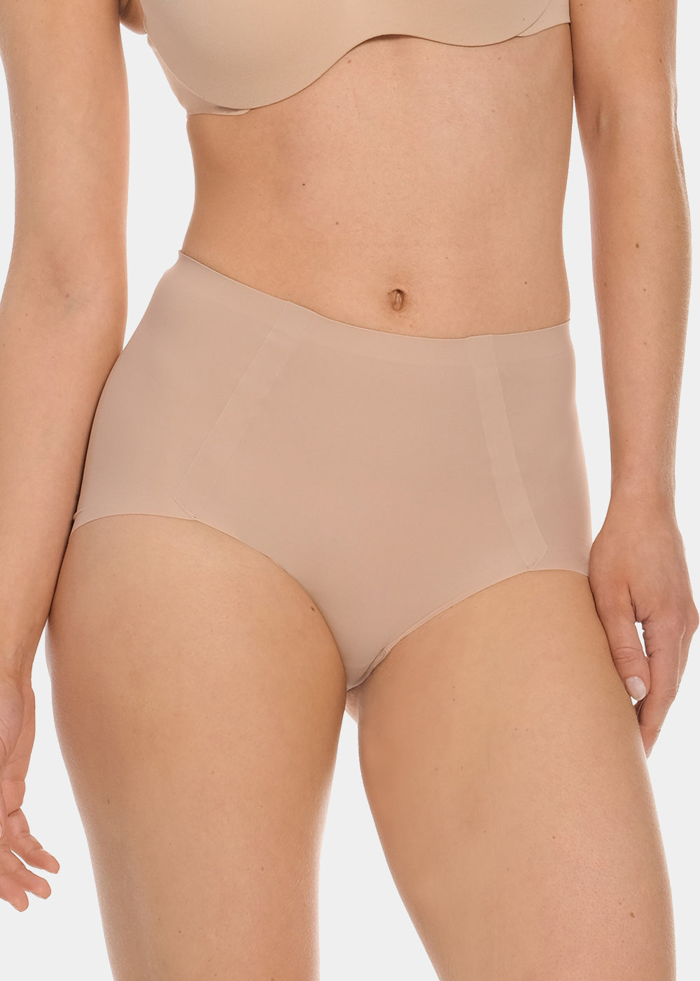 Front view of a model wearing Everyday Shaper Shorty in cappuccino, mid-waisted seamless shapewear shorts. Smooth fabric with short leg length, providing light shaping to lower tummy and back with invisible finish under clothing.