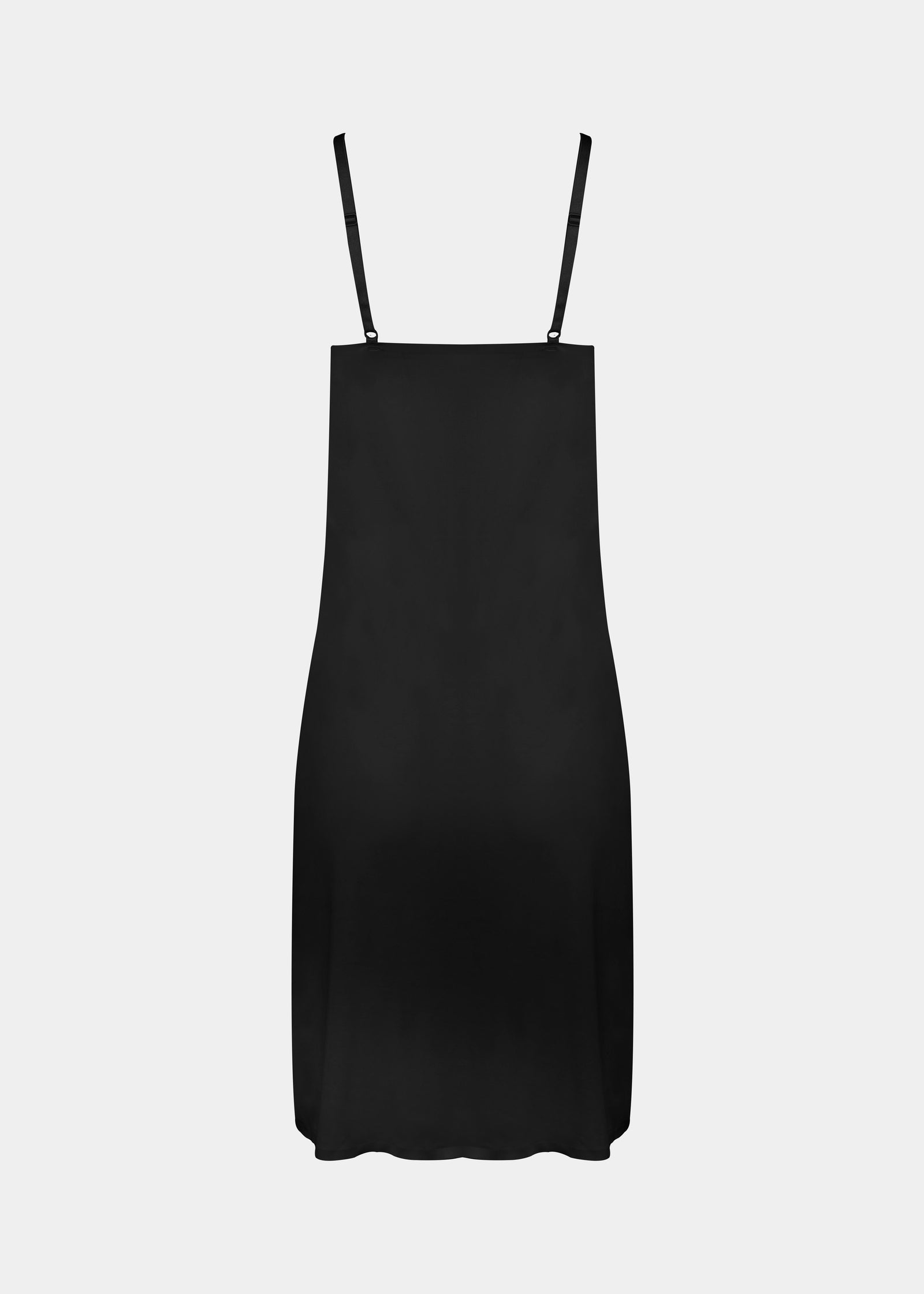 Still product image of Everyday Underdress in black shown from the back. Lightweight underdress with adjustable straps, smooth flowy fabric, and relaxed fit designed for invisible layering under clothing.