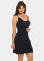 Front view of a model wearing Everyday Underdress in black, lightweight underdress with V-neckline and adjustable straps. Relaxed fit with smooth, flowy fabric and mid-thigh length designed for invisible layering under clothing.