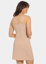 Back view of a model wearing Everyday Underdress in cappuccino, lightweight underdress with adjustable straps. Relaxed fit with smooth, flowy fabric and mid-thigh length, showing straight back design for invisible layering under clothing.
