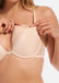 Front view close-up of a model wearing MAGIC Cups in latte, soft bra inserts placed inside a bra. Smooth seamless cups shaping the breast area, with natural curved outline visible under the fabric.