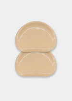 Still product image of Double Sticky Demi Push-Up Pads in latte showing the inside surface. Demi-shaped silicone insert with visible adhesive layer and smooth edges, designed to attach securely inside a bra cup.