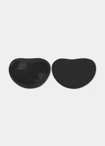 Still product image of Sticky Push-Up Pads in black showing inside and outside surfaces. Adhesive interior layer visible on one pad and smooth outer surface on the other, with curved shape and seamless edges.