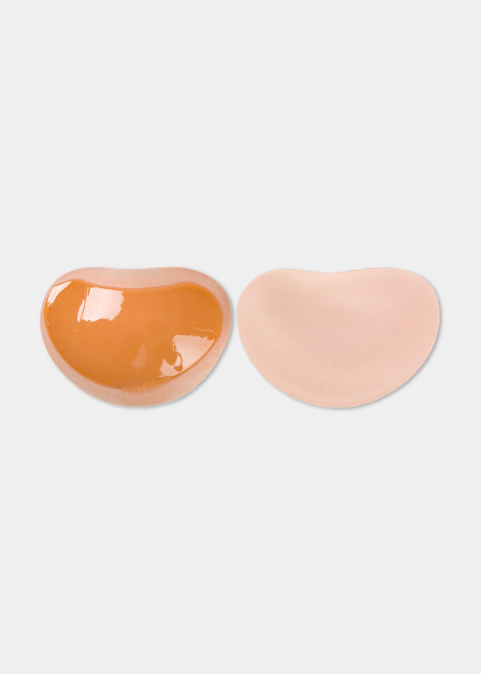 Still product image of Sticky Push-Up Pads in latte showing inside and outside surfaces. Adhesive interior layer visible on one pad and smooth outer surface on the other, with curved shape and seamless edges.