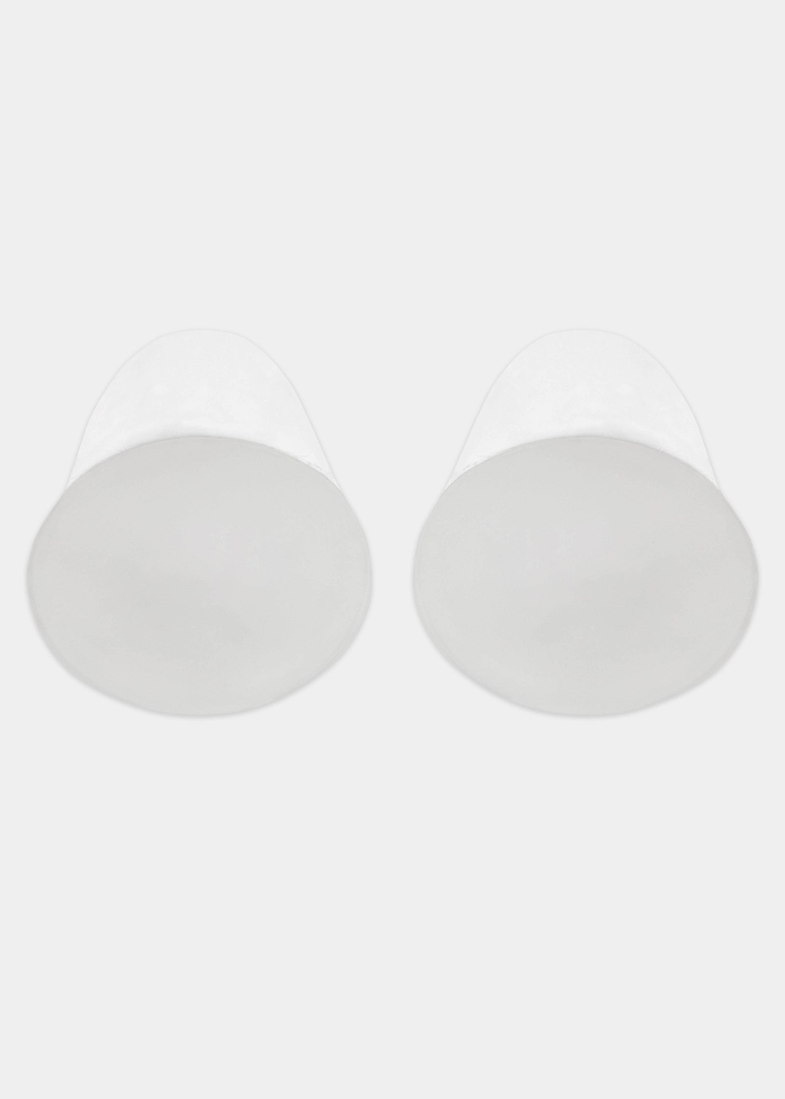 Still product image of MAGIC Lift-it’s in clear, adhesive silicone lifting cups with extended upper lifting tabs. Transparent seamless cups with smooth surface and visible adhesive interior for strapless, backless breast lift.