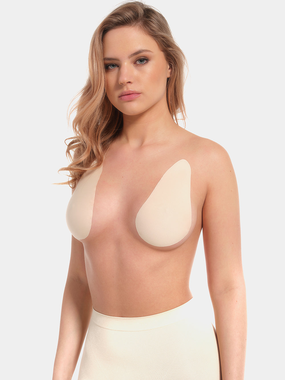 Front view of a model wearing the latte-colored Beverly Hills Secret breast lift tapes, showcasing the ultra-thin adhesive tapes that lift and support the bust while creating a smooth, invisible look under clothing.