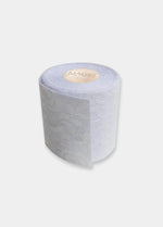 Still product image of the white Luxury Lace Boob Tape rolled up, showcasing the lace-textured adhesive tape on a roll designed to lift and shape the bust.