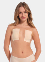 This image features a model demonstrating the use of the Boob Tape XL, which is designed to lift and support breasts without the need for a bra. The tape appears skin-friendly and stretchy, with a beige color that blends well with skin tones.