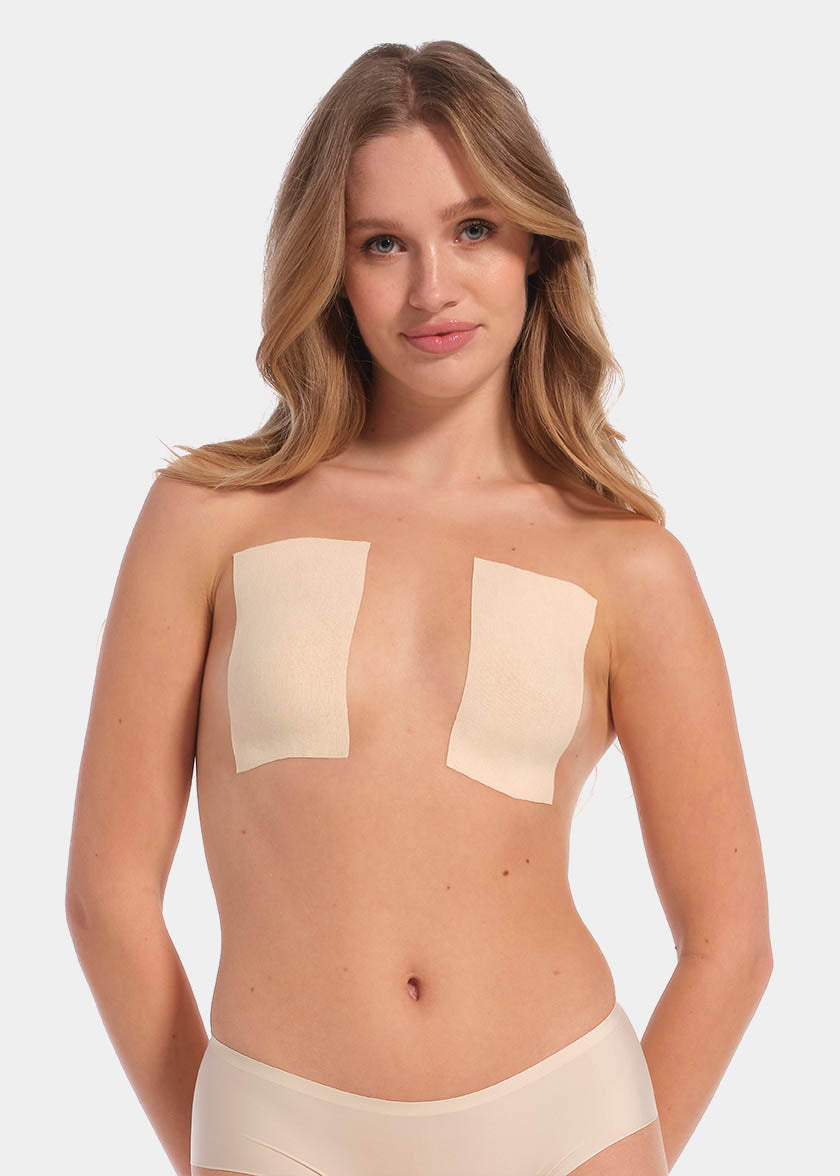 This image features a model demonstrating the use of the Boob Tape XL, which is designed to lift and support breasts without the need for a bra. The tape appears skin-friendly and stretchy, with a beige color that blends well with skin tones.