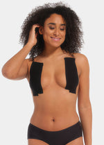 Front view of a model wearing the black MAGIC Bodyfashion Breast Tape, showcasing the adhesive tape applied to lift and shape the bust while creating a smooth, invisible look under clothing.