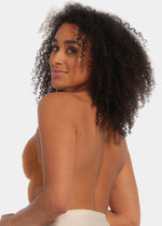 Back view of a model wearing the mocha-colored MAGIC Bodyfashion Breast Tape, showcasing the backless design while the adhesive tape provides lift and support to the bust with an invisible finish.