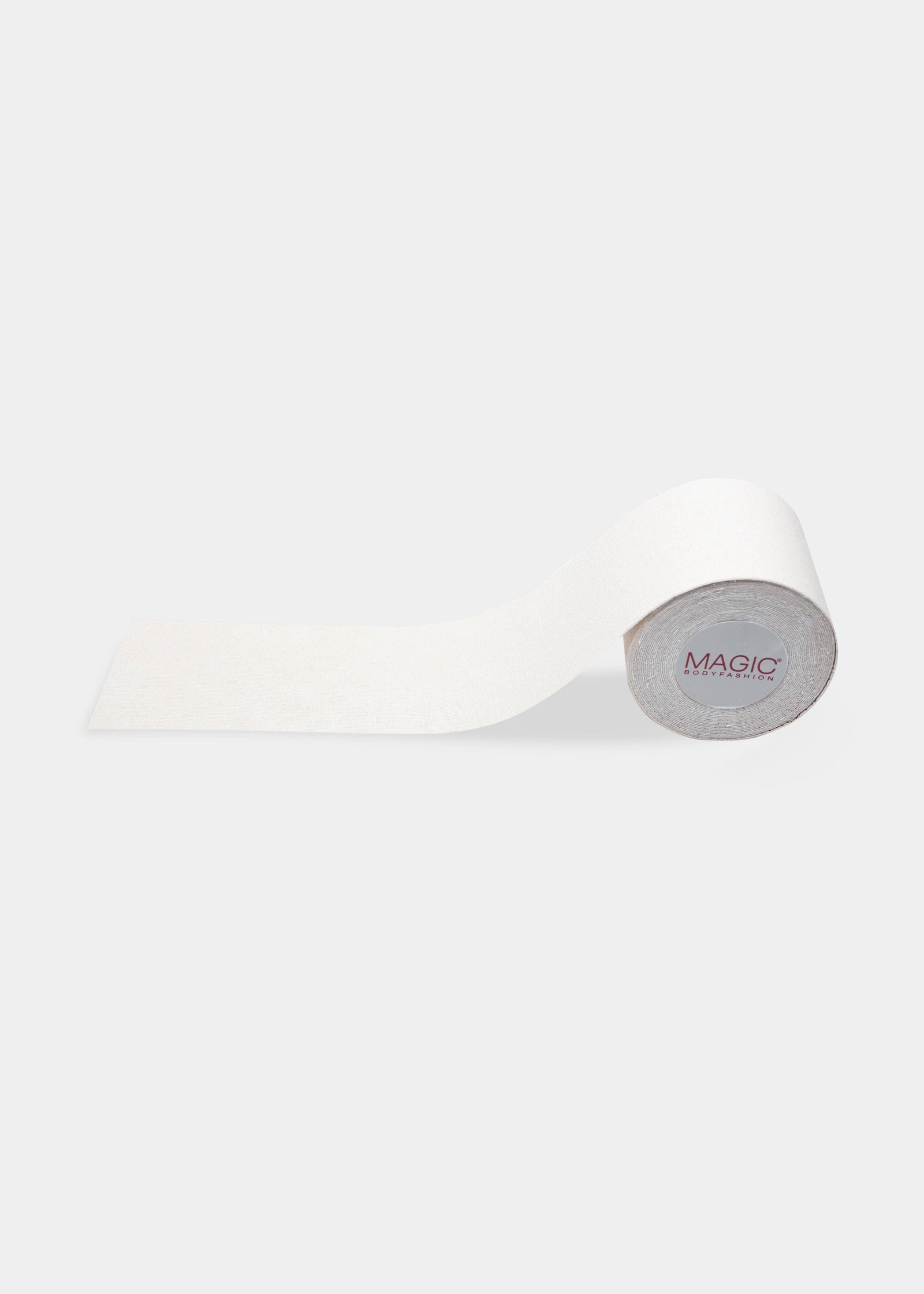 Still product image of the white MAGIC Bodyfashion Breast Tape roll, showcasing the adhesive tape designed to lift and shape the bust for invisible styling.