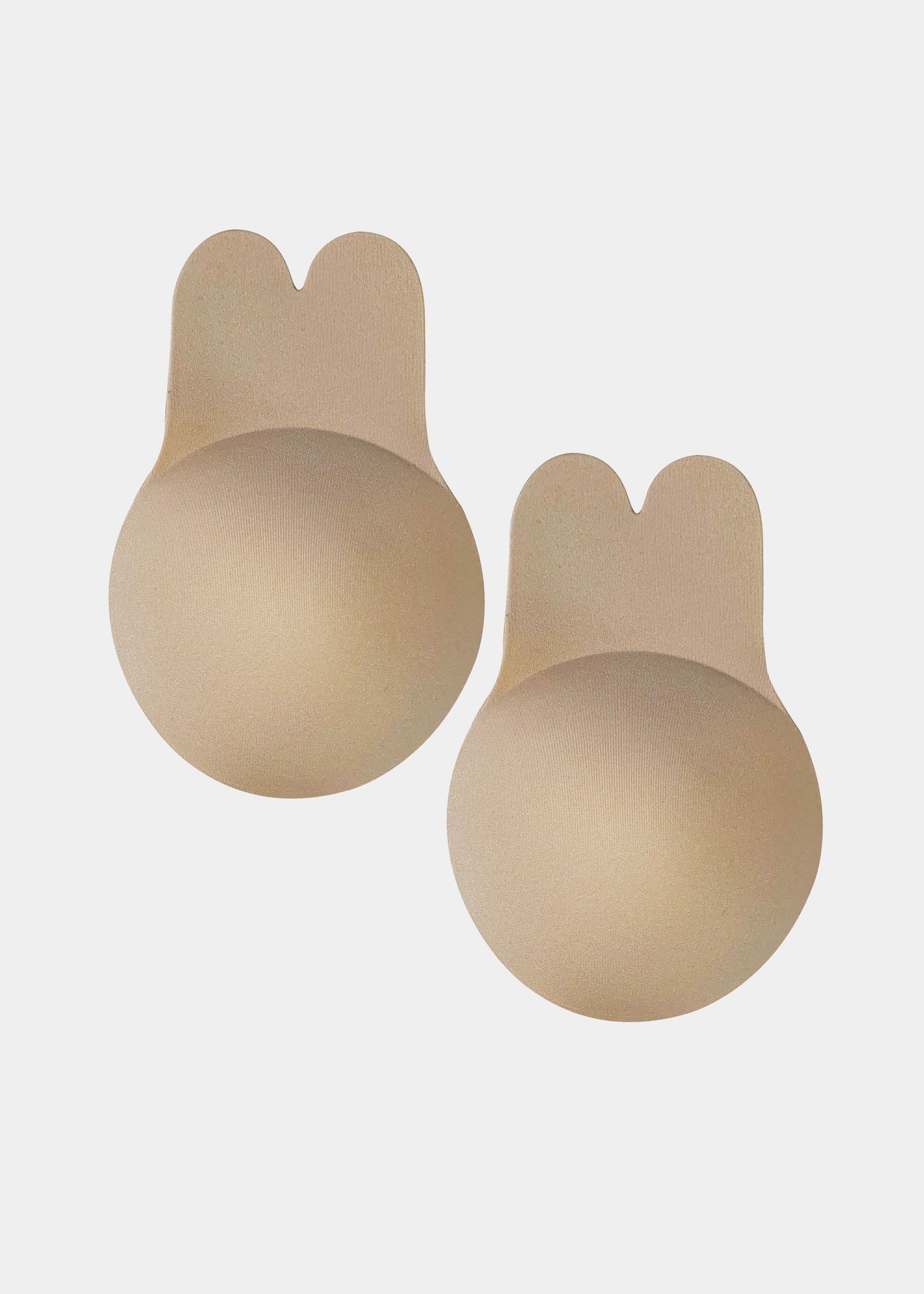 Still front product view of the latte-colored Lift Covers, showcasing the smooth lifting nipple covers with adhesive support tabs and a seamless finish for invisible coverage.