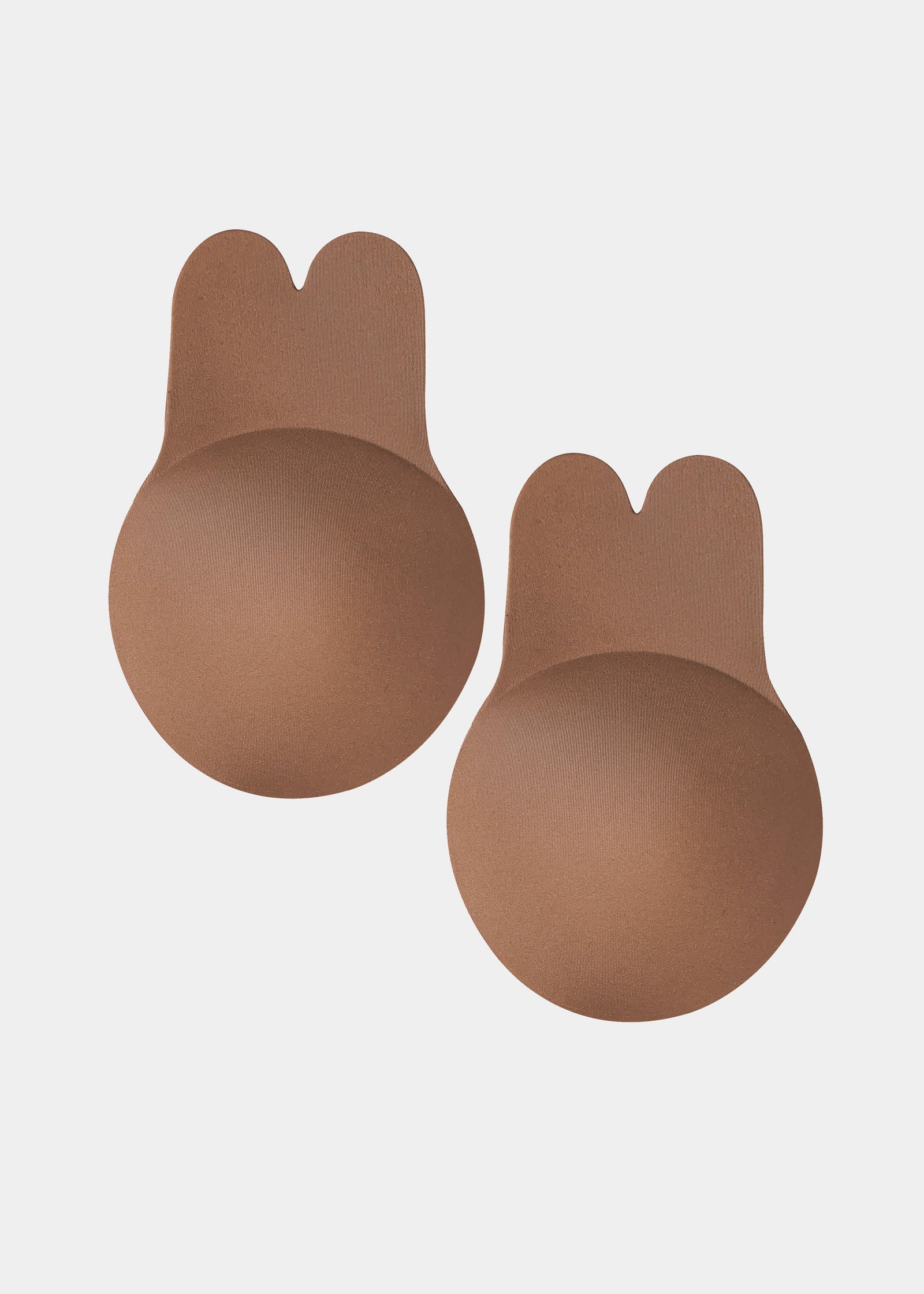 Still front product view of the mocha-colored Lift Covers, showcasing the smooth lifting nipple covers with adhesive support tabs and a seamless finish for invisible coverage.