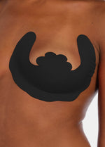 Front view of a model wearing the black Freedom Form adhesive breast lift strips, showcasing the strapless and backless design that lifts and supports the bust while remaining invisible under clothing.