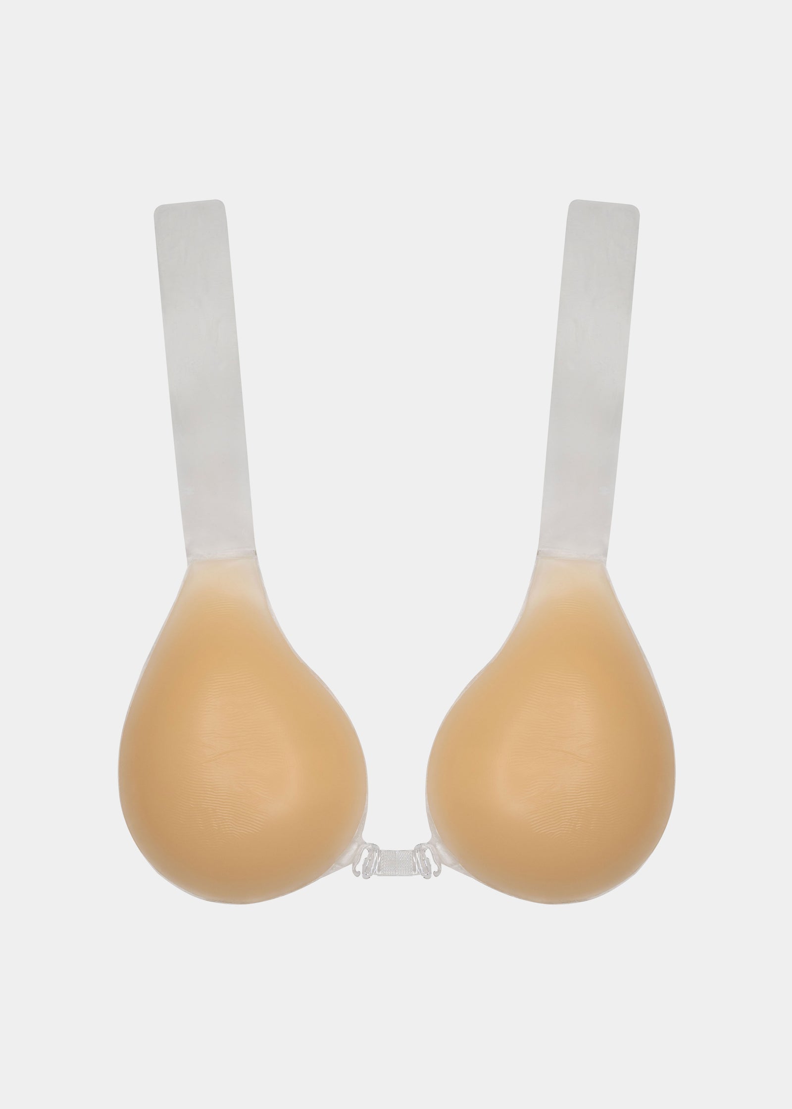 An adhesive bra with two silicone cups and transparent lifting straps, designed for strapless and backless outfits.