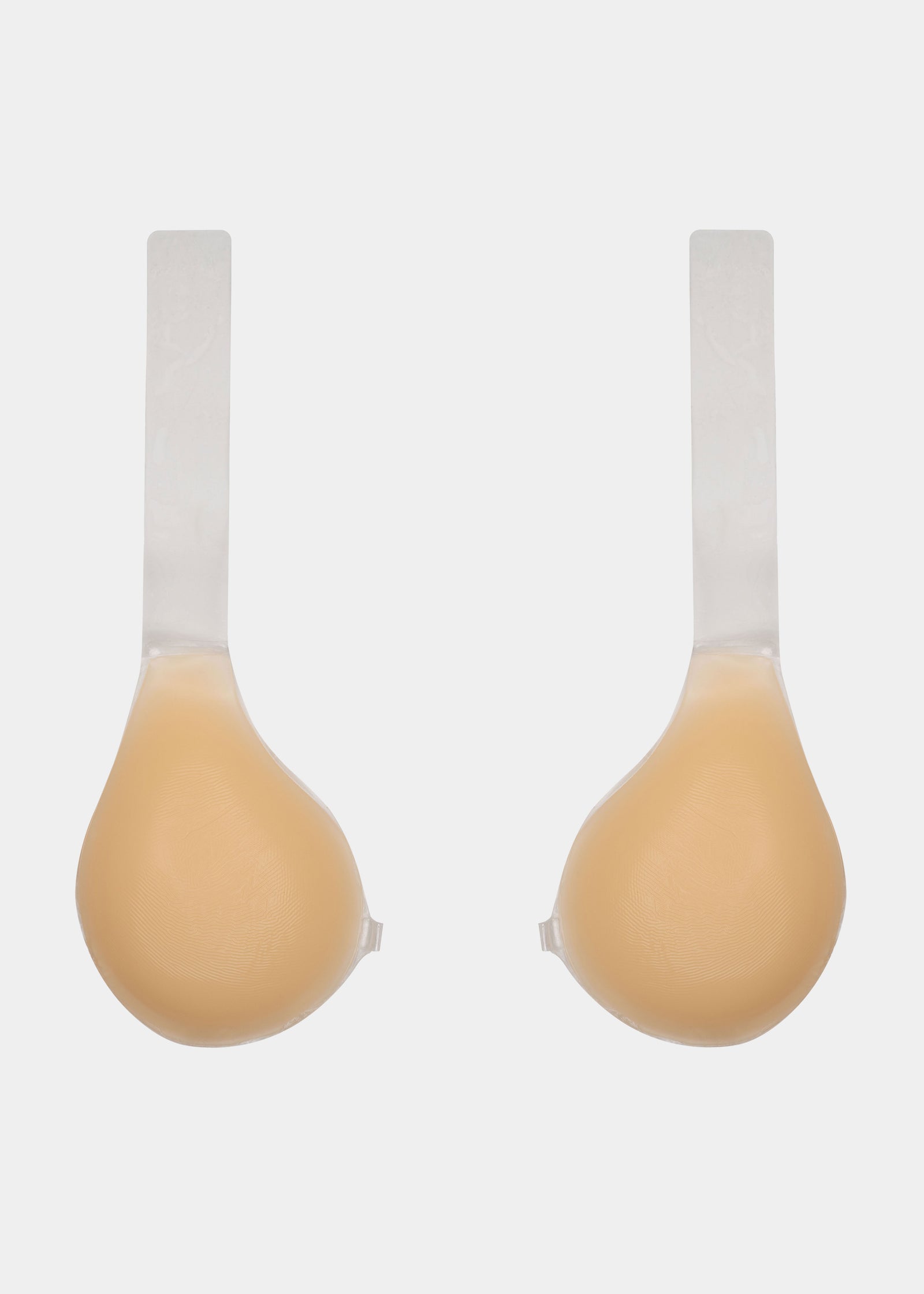 Still front product view of the latte-colored Shapely Bra with the front closure open, showcasing the separate silicone cups, transparent lifting straps, and skin-friendly adhesive surface.