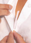 Front view of a model wearing an outfit secured with Magic Dress Tape, showing how the transparent double-sided tape keeps the clothing in place for a smooth, secure, and invisible fit.
