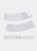 Still product image of Magic Dress Tape, displaying multiple transparent double-sided adhesive strips in different shapes and sizes, designed to keep clothing securely in place.