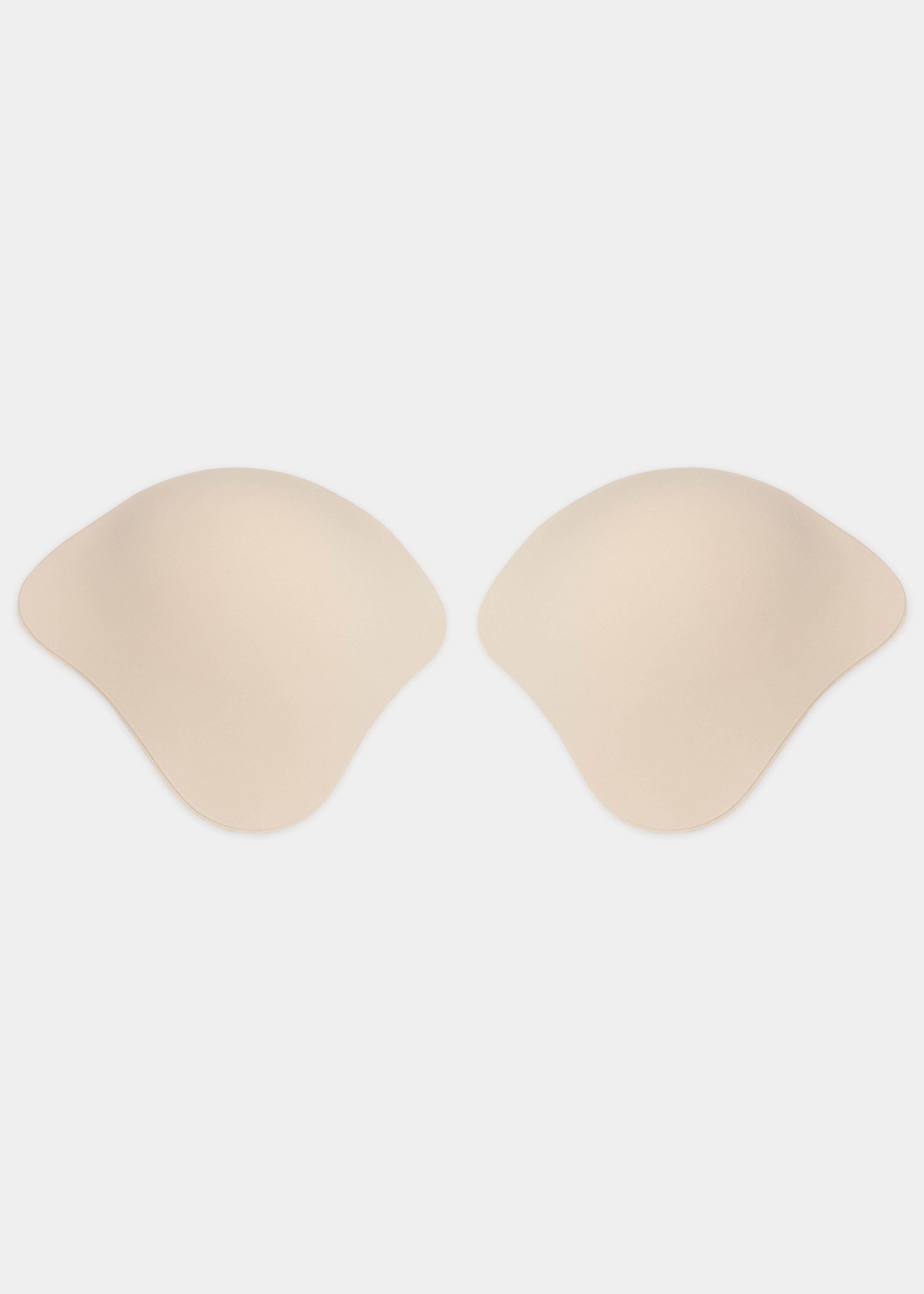 Still front product view of the latte-colored Ultimate Invisibles adhesive bra cups, showcasing the two separate lightweight cups with a smooth outer finish and skin-friendly adhesive lining for a seamless, invisible look.
