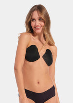 Front view of a model wearing the Ultimate Invisibles adhesive bra cups, showcasing the lightweight, backless and strapless design with two separate smooth cups that create natural-looking cleavage and an invisible finish under clothing.