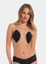 Front view of a model wearing the Ultimate Invisibles adhesive bra cups, showcasing the lightweight, backless and strapless design with two separate smooth cups that create natural-looking cleavage and an invisible finish under clothing.