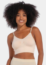 Front view of a model wearing the latte-colored Bamboo Low Back Bra, featuring a seamless, wireless design made from soft bamboo fabric. The bra includes built-in support, removable inlay pads for shaping, and adjustable spaghetti straps for a customized fit.