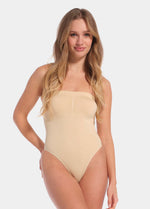 Front view of a model wearing the latte-colored Bandeau Thong Body, featuring a seamless, wireless bandeau design with built-in bust support, medium shaping through the waist and tummy, and a smooth, strapless silhouette.