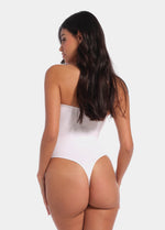 Back view of a model wearing the white Bandeau Thong Body, showcasing the seamless design with medium shaping through the waist and back, a smooth strapless finish, and a thong cut for an invisible look under clothing.