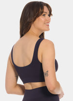 Woman wearing a dark blue Bamboo Comfort Bra and leggings on a white background