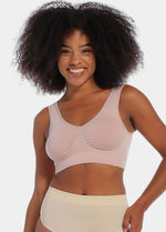 Woman wearing a light pink Bamboo Comfort Bra  and shorts on a plain background