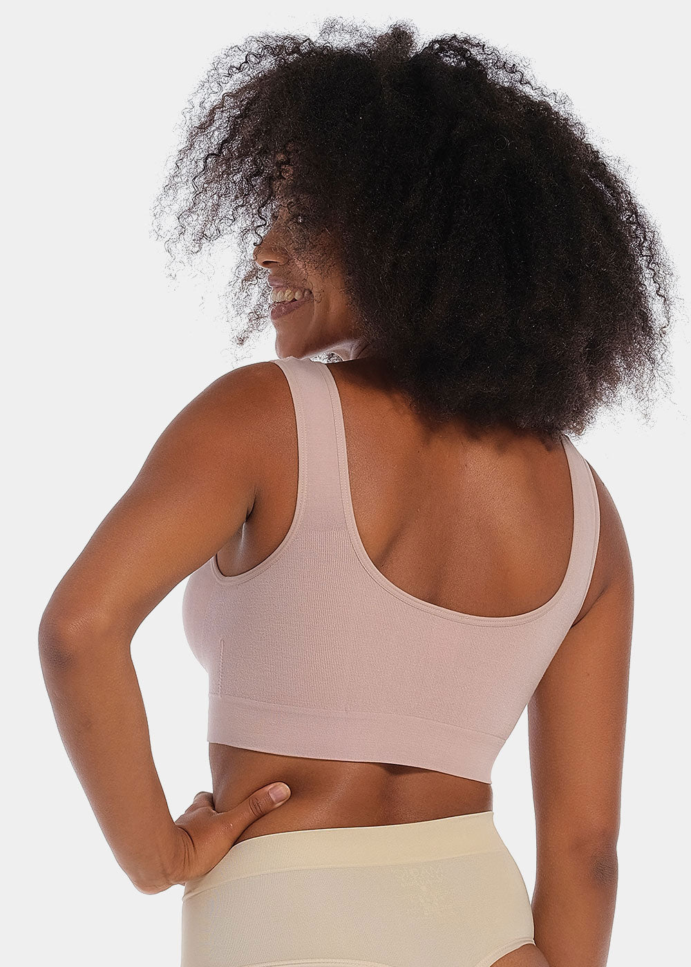 Woman wearing a light pink Bamboo Comfort Bra and shorts on a white background