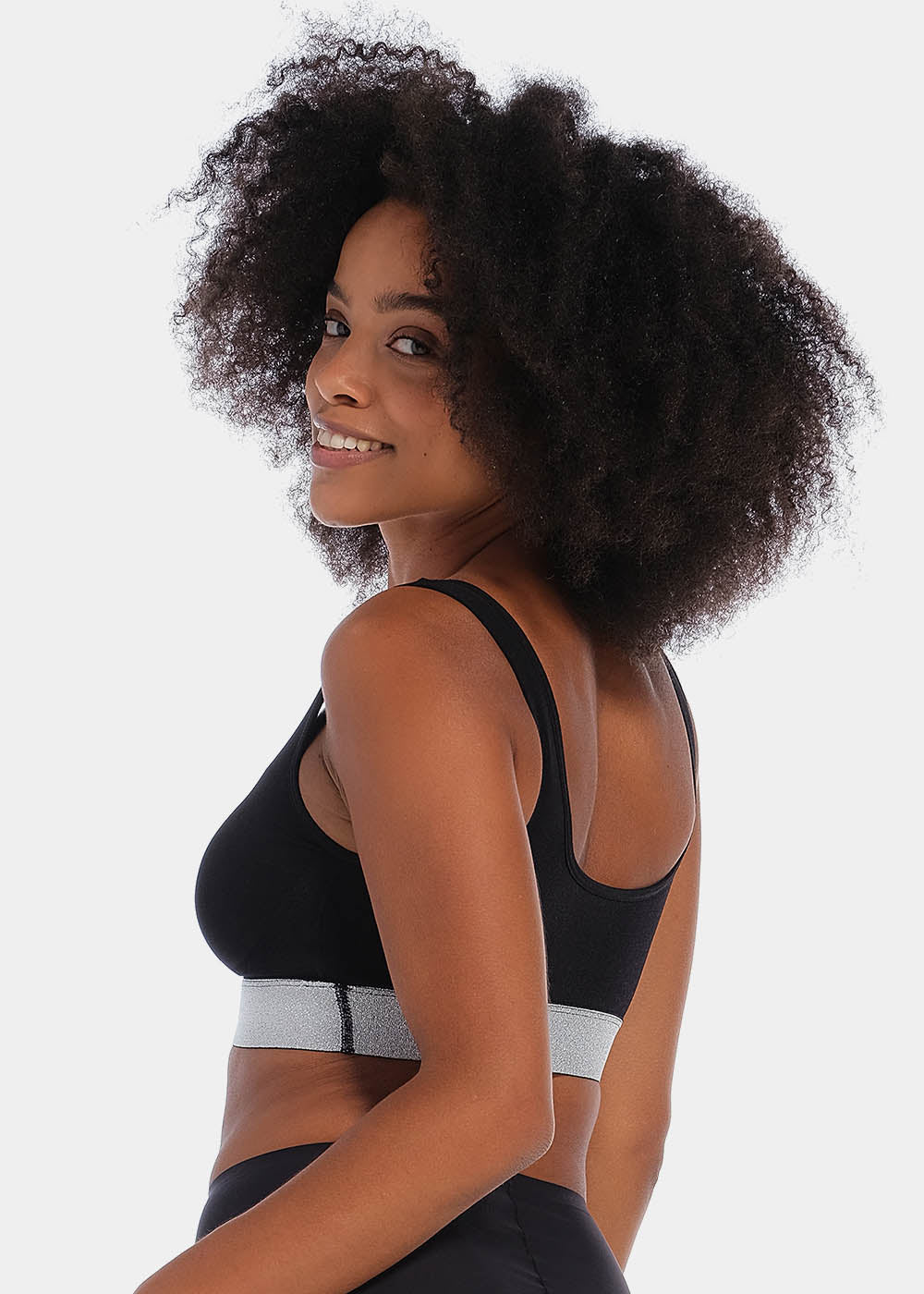 Front view of a model wearing the Salsa Bra, featuring a soft, seamless wireless design with wide supportive straps and removable pads. The bra has built-in support and a silver sparkling band under the bust that adds a subtle, stylish shimmer.