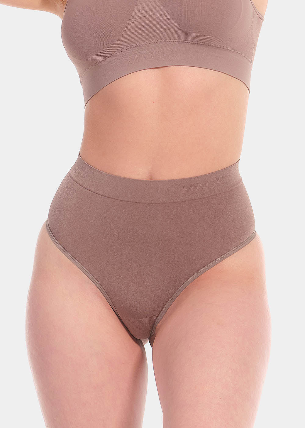 Front view of a model wearing the espresso Comfort Thong, featuring soft, seamless fabric with light shaping support through the lower tummy and a smooth, invisible finish under clothing.