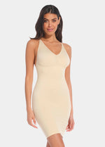 A model wearing a latte low back, low front dress with spaghetti straps and a mini skirt length.