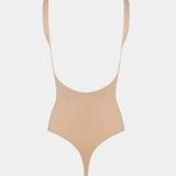 Beige swimsuit with thin straps on a light gray background