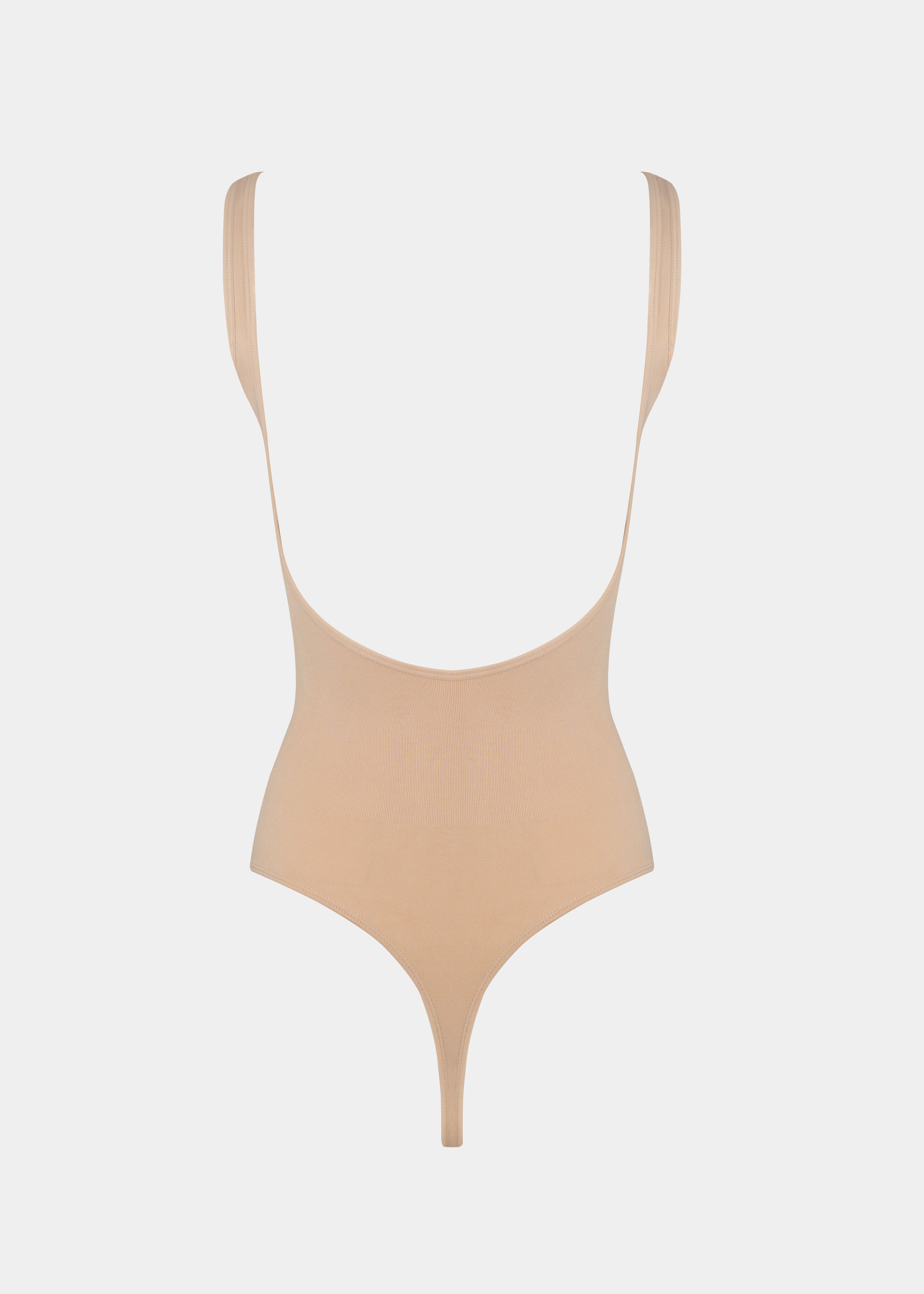 Beige swimsuit with thin straps on a light gray background