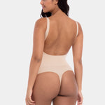 Woman wearing a beige bodysuit on a white background