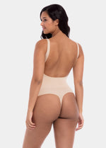 Woman wearing a beige bodysuit on a white background