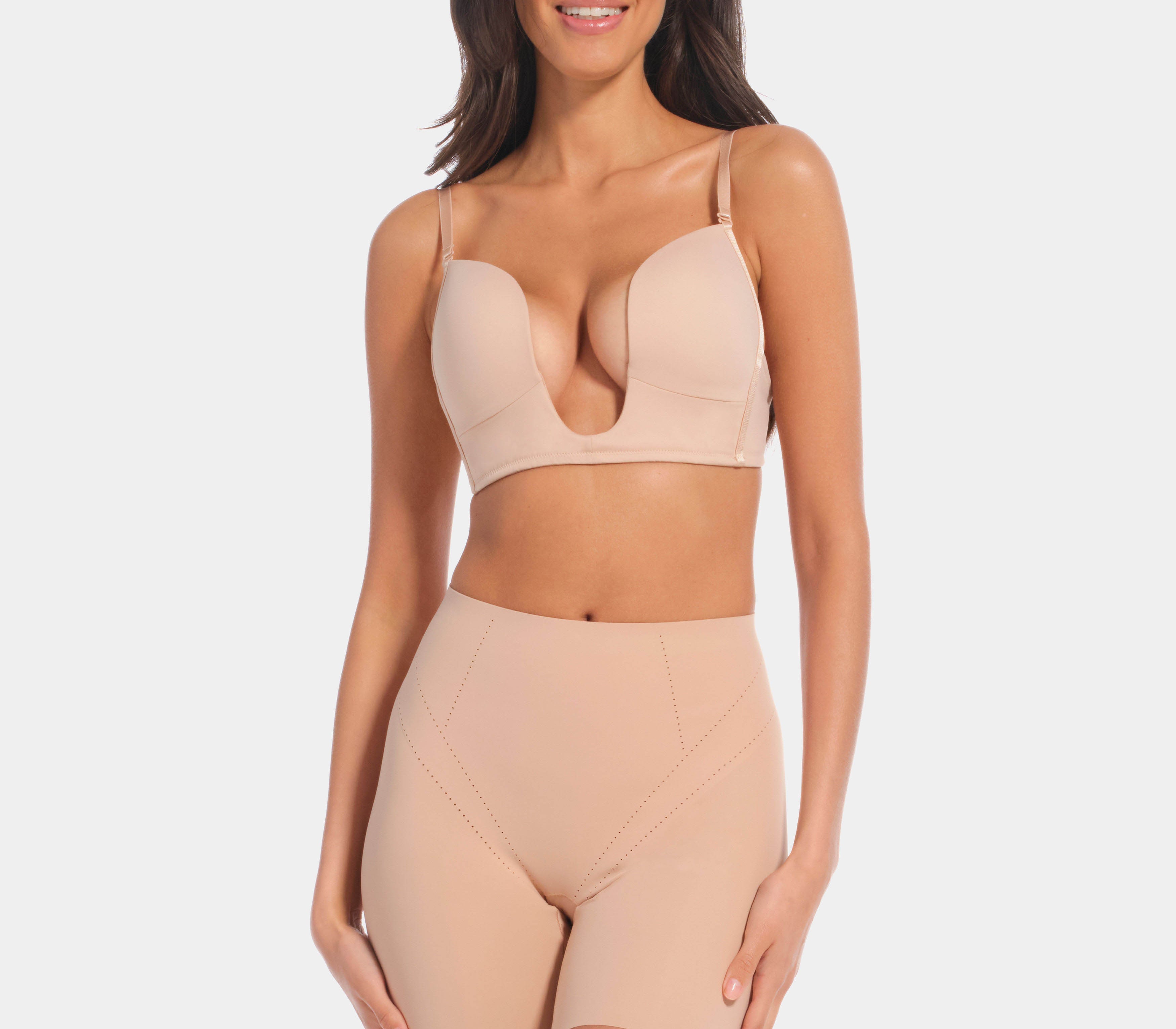 A person wearing a beige Dream Shaper Short that reaches mid-thigh, designed for shaping the lower back, tummy, and upper legs.