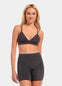 Woman wearing a dark gray sports bra and shorts set on a light gray background