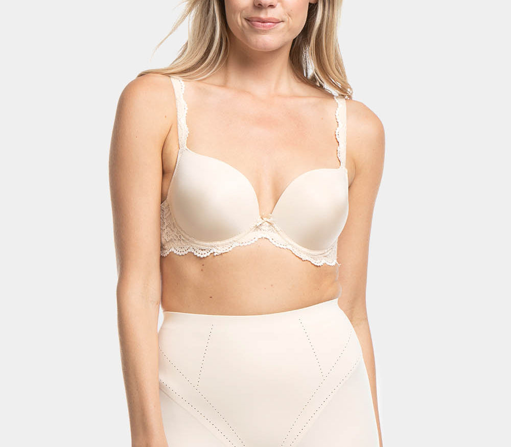 A person wearing a beige Dream Shaper Short that reaches mid-thigh, designed for shaping the lower back, tummy, and upper legs.