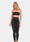 A woman wearing a black Gloss Legging with a high waist, standing against a white background.