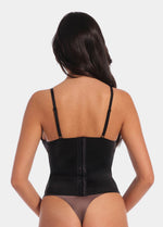 A woman wearing the Gloss Low Plunge Top. Showing the straps and back of the product.