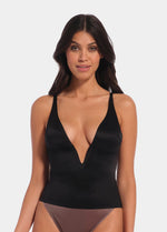 A woman wearing a black low plunge top with adjustable straps and a deep V-neckline.