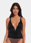 A woman wearing a black low plunge top with adjustable straps and a deep V-neckline.